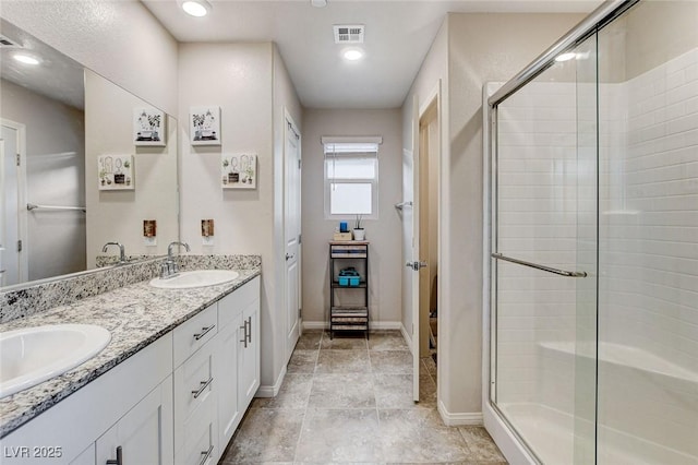 bathroom with a sink, a stall shower, and baseboards