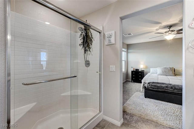 ensuite bathroom with visible vents, a ceiling fan, ensuite bathroom, a shower stall, and baseboards