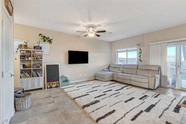 living room with a ceiling fan, visible vents, and baseboards