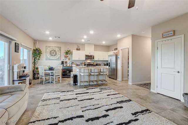 living room with recessed lighting, visible vents, baseboards, and a ceiling fan