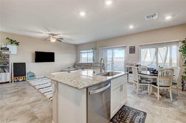 kitchen with light stone countertops, dishwasher, ceiling fan, a sink, and white cabinets