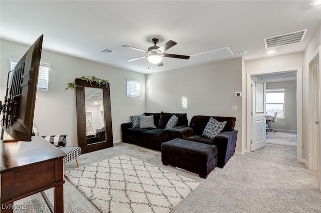 living area with carpet flooring, visible vents, and ceiling fan