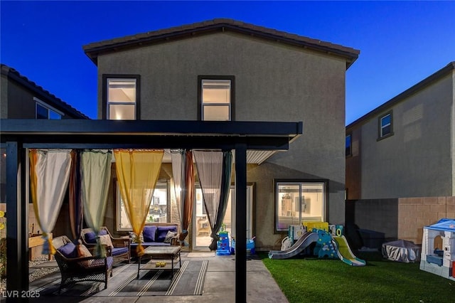 back of house with stucco siding, an outdoor hangout area, and a patio