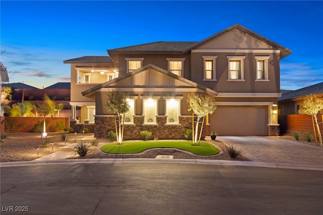 view of front of house with stone siding, decorative driveway, an attached garage, and stucco siding