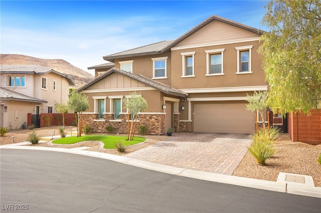 view of front of home with fence, an attached garage, stucco siding, decorative driveway, and a mountain view