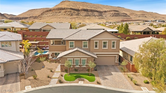 view of front facade featuring an attached garage, fence, a residential view, stucco siding, and driveway