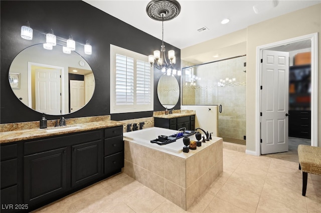 bathroom with tile patterned floors, a stall shower, an inviting chandelier, a bath, and vanity