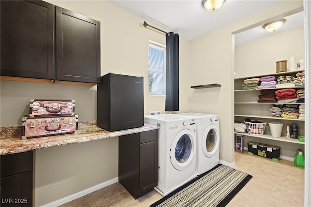 laundry area featuring light tile patterned flooring, cabinet space, baseboards, and separate washer and dryer