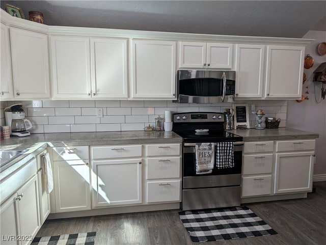 kitchen with decorative backsplash, white cabinetry, stainless steel appliances, and wood finished floors