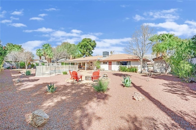 rear view of house with a patio area, fence, and a fire pit