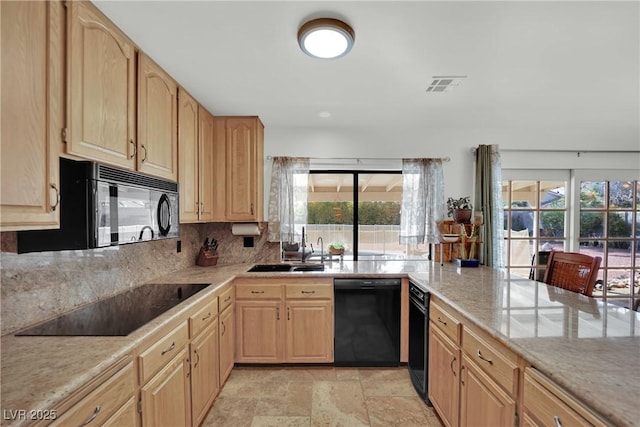 kitchen with a sink, visible vents, light brown cabinetry, black appliances, and plenty of natural light