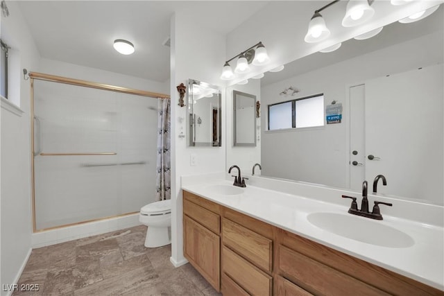 bathroom with toilet, curtained shower, double vanity, and a sink