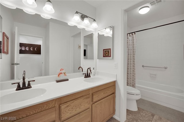 full bathroom with visible vents, a sink, toilet, and double vanity