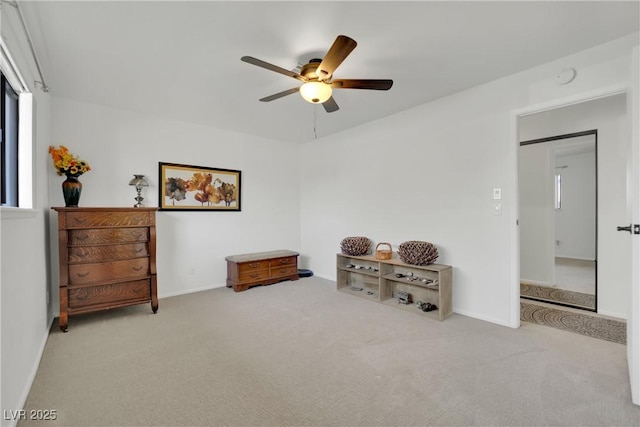 interior space with carpet floors, baseboards, and a ceiling fan