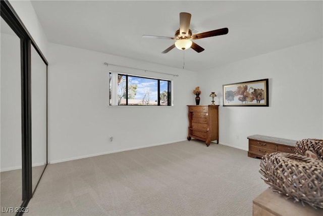 sitting room with a ceiling fan, light colored carpet, and baseboards