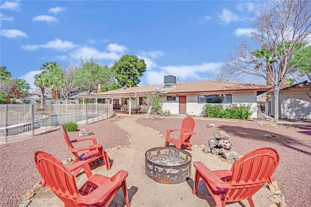 rear view of house with an outdoor fire pit, a patio, a tiled roof, fence, and central AC