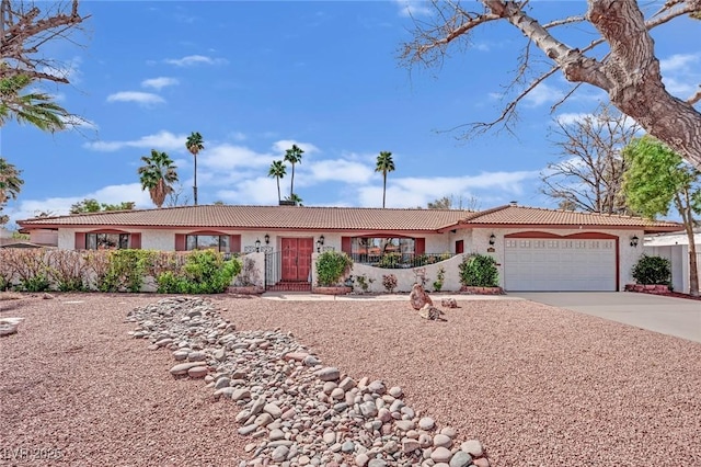 single story home featuring an attached garage, fence, concrete driveway, and stucco siding