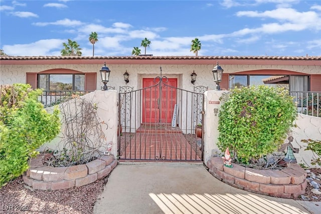 view of exterior entry featuring fence and stucco siding