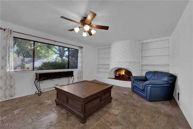 3681 S Rosecrest Cir, Las Vegas, NV 89121 - living room featuring built in shelves, ceiling fan, a fireplace, and stone finish flooring