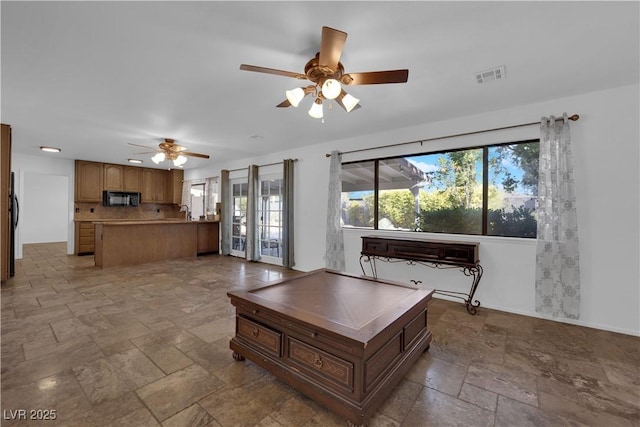 3681 S Rosecrest Cir, Las Vegas, NV 89121 - living room with stone tile floors, a ceiling fan, and healthy amount of natural light