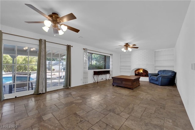 3681 S Rosecrest Cir, Las Vegas, NV 89121 - living area featuring built in features, ceiling fan, stone tile floors, and a brick fireplace