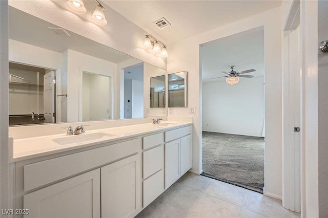 bathroom featuring tile patterned flooring, a sink, visible vents, a ceiling fan, and double vanity