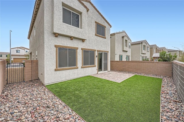 rear view of house with a patio area, a fenced backyard, a lawn, and stucco siding