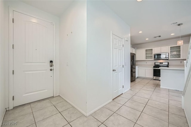 foyer featuring light tile patterned floors, baseboards, visible vents, and recessed lighting