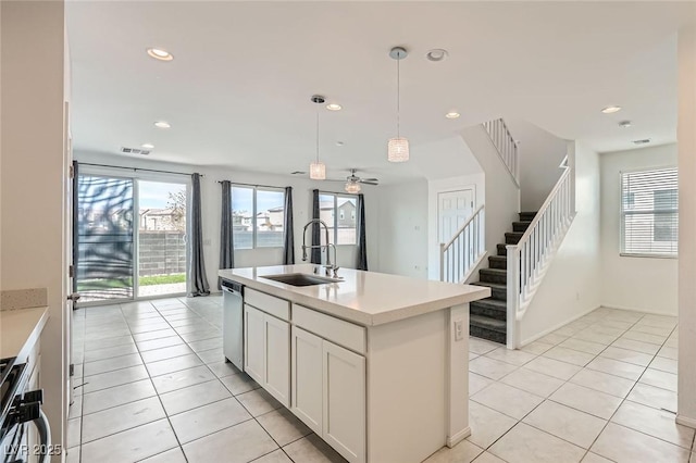 kitchen featuring a wealth of natural light, stove, a sink, stainless steel dishwasher, and light tile patterned flooring