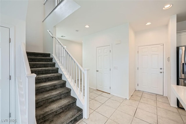 staircase with tile patterned flooring, baseboards, and recessed lighting