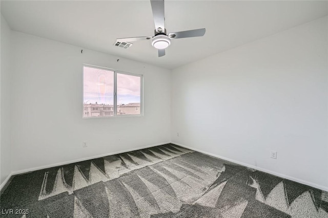 carpeted spare room with a ceiling fan, visible vents, and baseboards