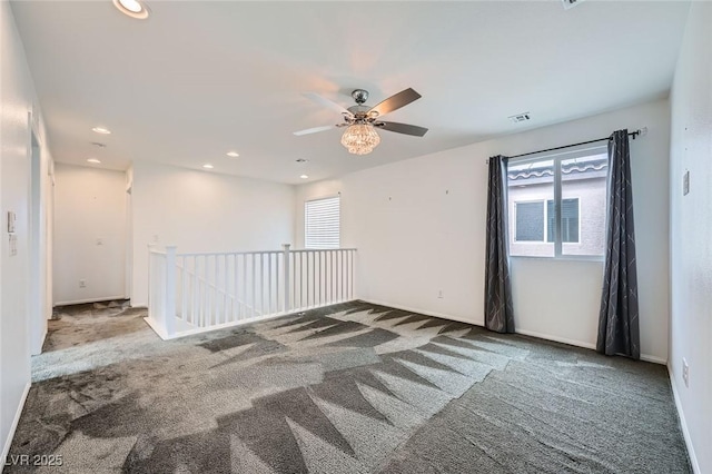 carpeted spare room featuring plenty of natural light, visible vents, baseboards, and recessed lighting