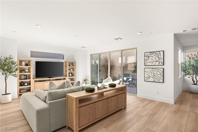 living area featuring light wood-style flooring, visible vents, baseboards, and recessed lighting