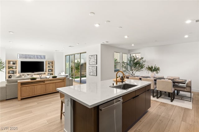 kitchen with open floor plan, light wood-type flooring, a sink, and dishwasher