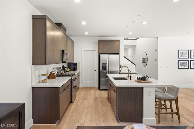 kitchen featuring stainless steel appliances, a sink, and dark brown cabinets