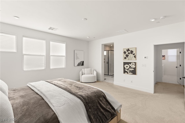 bedroom featuring light colored carpet, visible vents, baseboards, and ensuite bathroom