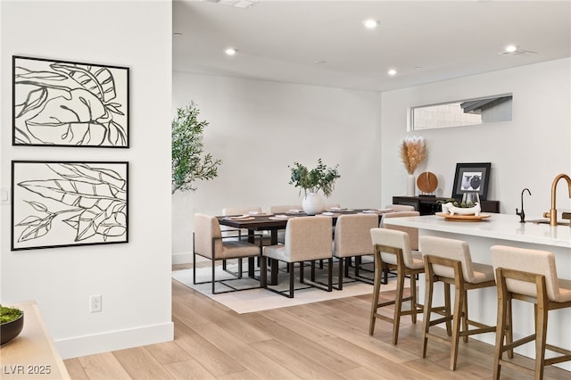 dining space featuring recessed lighting, baseboards, and light wood finished floors