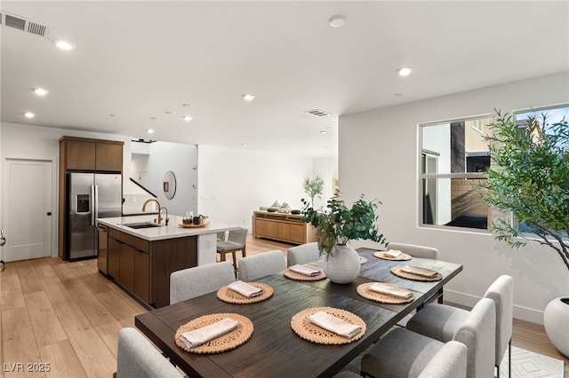 dining room featuring light wood finished floors, visible vents, and recessed lighting