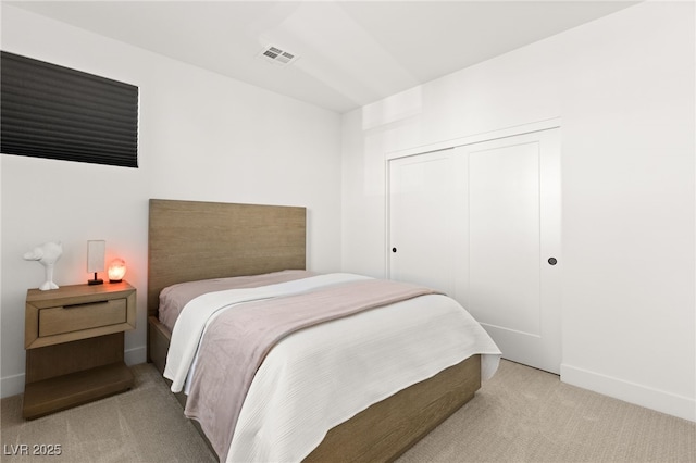 bedroom featuring carpet floors, a closet, visible vents, and baseboards