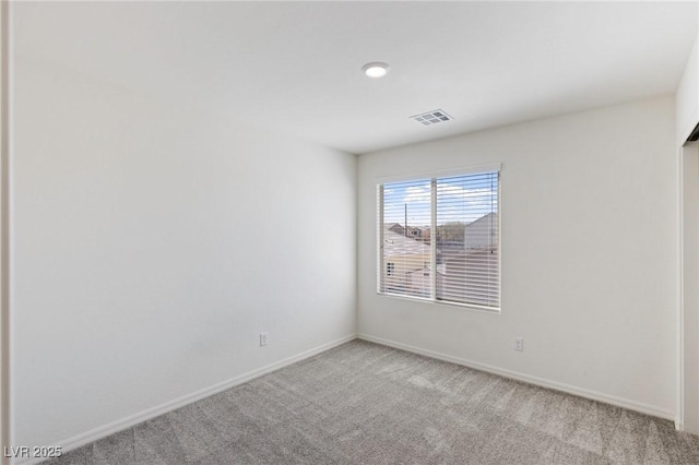 empty room featuring baseboards, visible vents, and light colored carpet