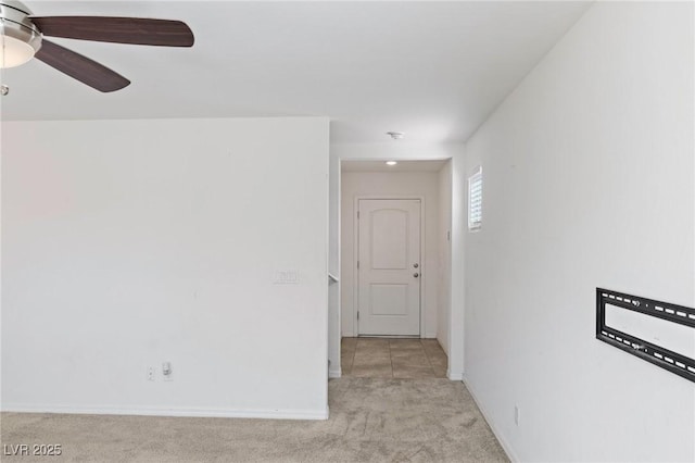 unfurnished room featuring light carpet, ceiling fan, and baseboards