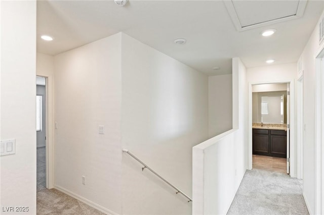 corridor with baseboards, recessed lighting, an upstairs landing, and light colored carpet