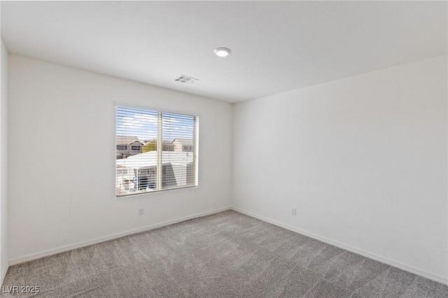 empty room with baseboards, visible vents, and carpet flooring