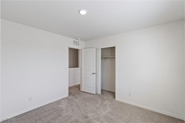 unfurnished bedroom with baseboards, a closet, visible vents, and carpet flooring