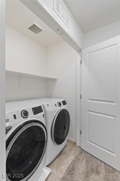 washroom with laundry area, visible vents, and washing machine and clothes dryer