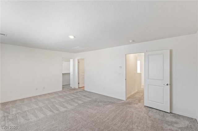 empty room featuring light carpet, visible vents, and baseboards