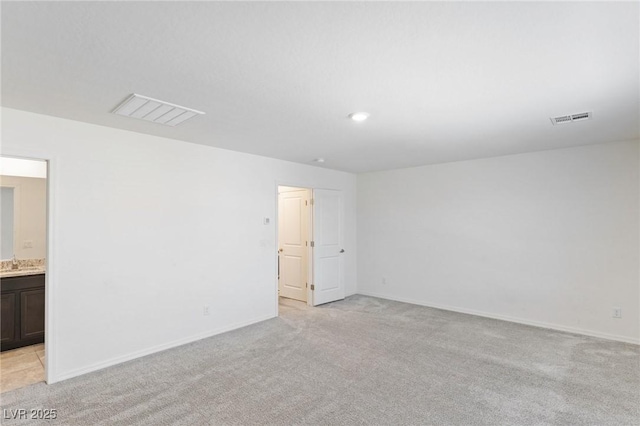 empty room with light colored carpet and visible vents