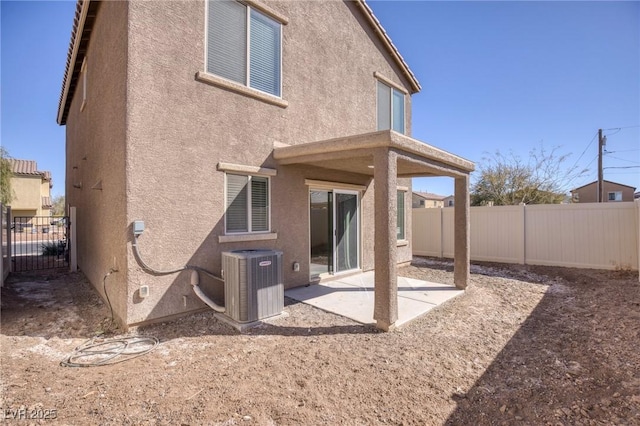 rear view of house featuring cooling unit, a patio area, a fenced backyard, and stucco siding