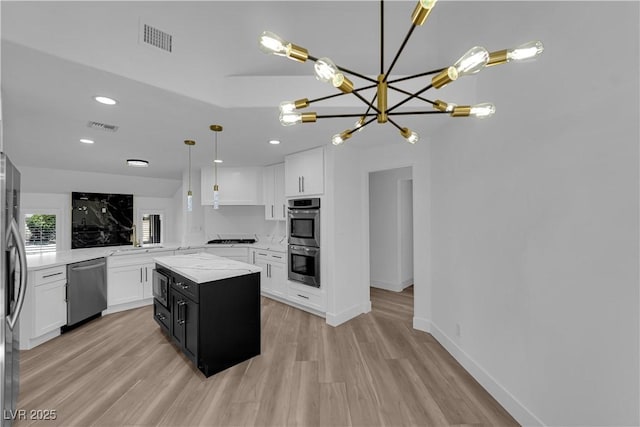 kitchen with visible vents, appliances with stainless steel finishes, white cabinets, and dark cabinetry