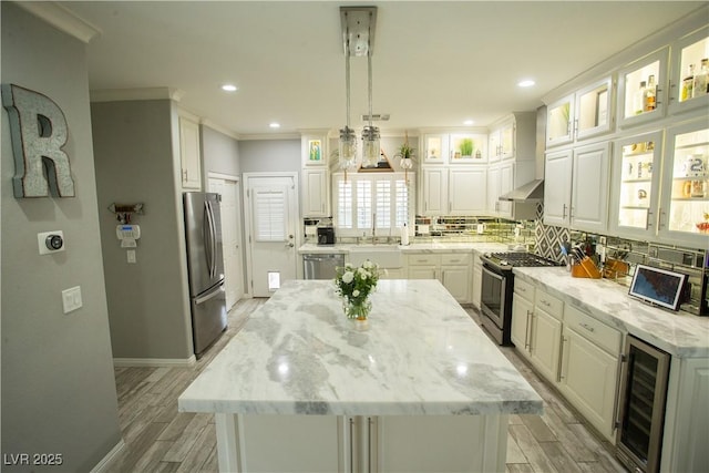 kitchen featuring beverage cooler, decorative backsplash, appliances with stainless steel finishes, and white cabinetry